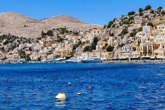 Isla de Tilos, en el Dodecaneso: panorama desde el mar con barcos y ciudad al fondo